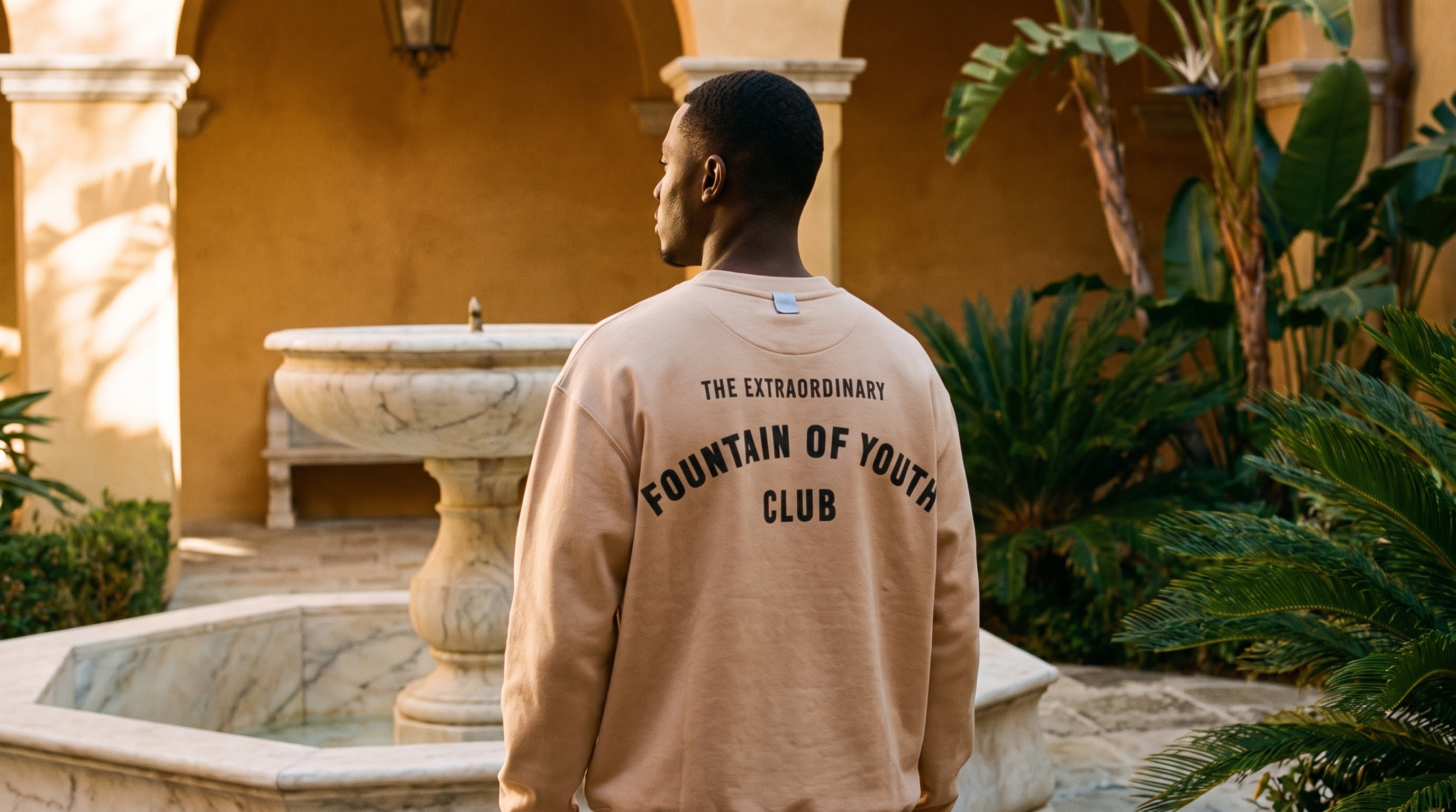 The Extraordinary Fountain of Youth Club arch print, worn at a sunlit courtyard fountain